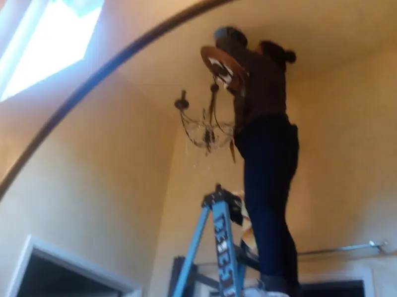 Electrician installing a chandelier in a Gary residence